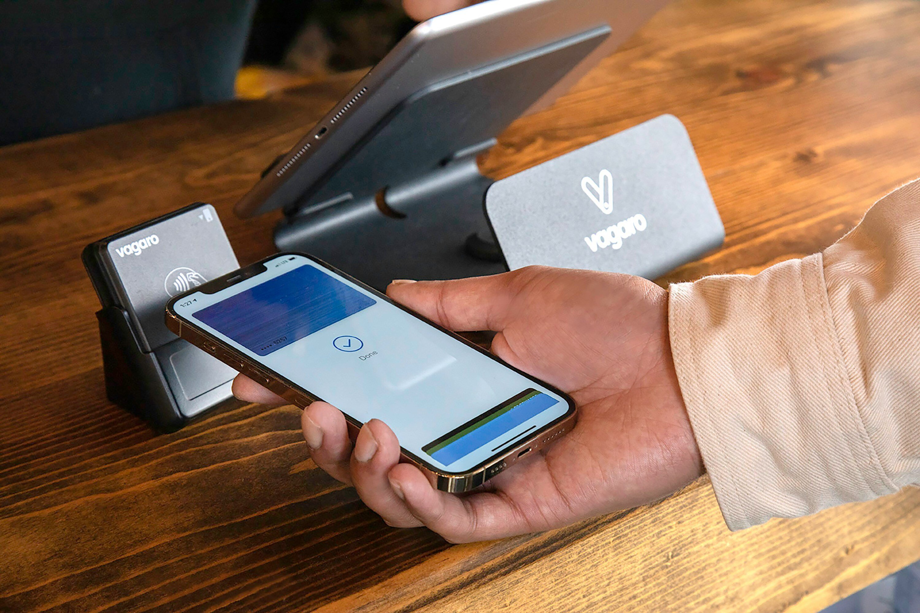 A person uses their cell phone to pay for something at a cash register